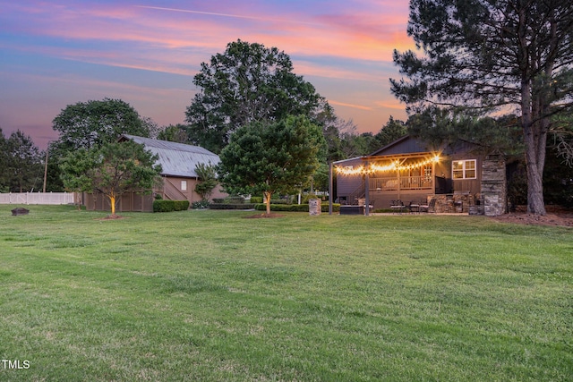 yard at dusk featuring an outdoor structure and a barn