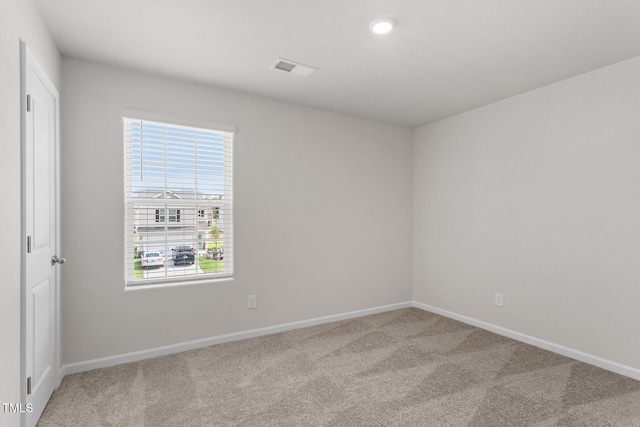 unfurnished room with carpet flooring, visible vents, and baseboards