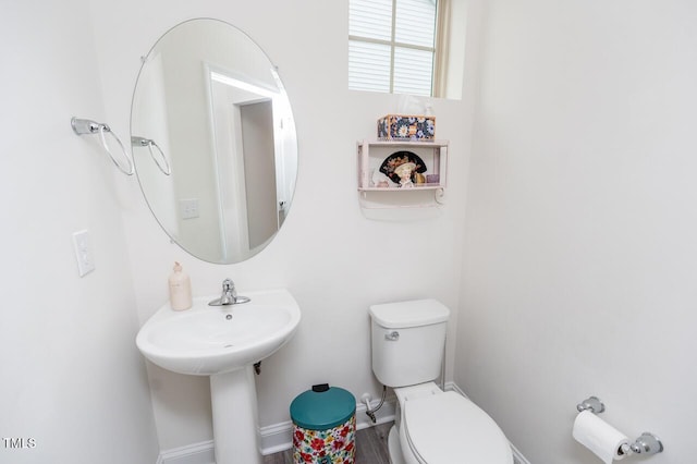 bathroom featuring toilet and baseboards