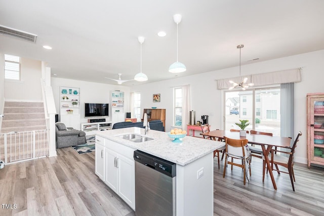 kitchen with dishwasher, light wood finished floors, a sink, and visible vents