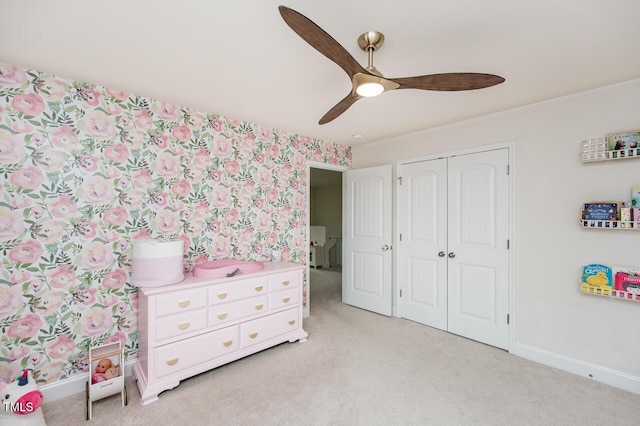 bedroom with a closet, light carpet, and baseboards