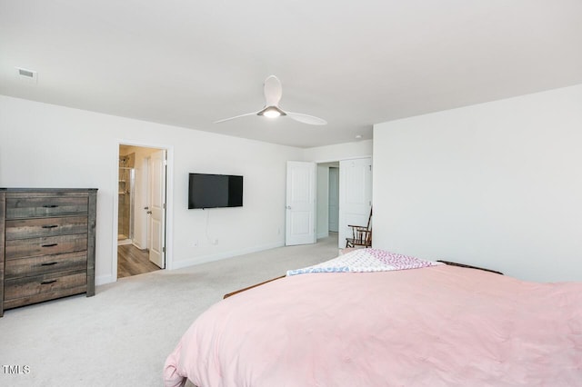 bedroom featuring ceiling fan, ensuite bathroom, visible vents, baseboards, and carpet