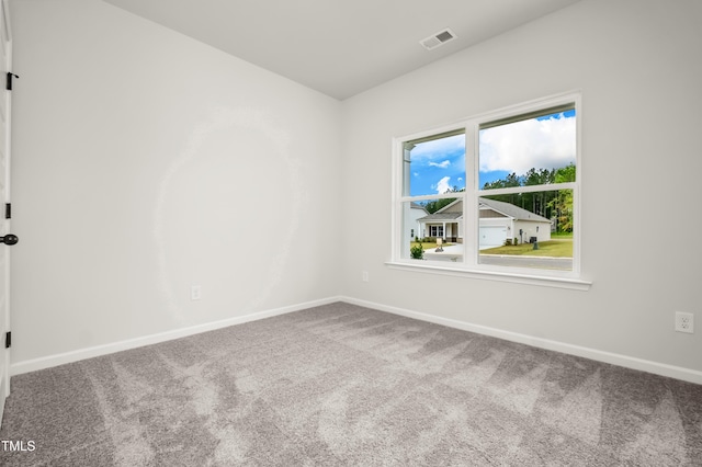 unfurnished room featuring carpet, visible vents, and baseboards