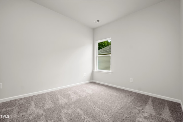 empty room with carpet flooring, visible vents, and baseboards