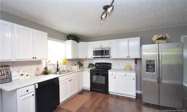 kitchen featuring white cabinets, decorative backsplash, dark wood finished floors, black appliances, and a sink