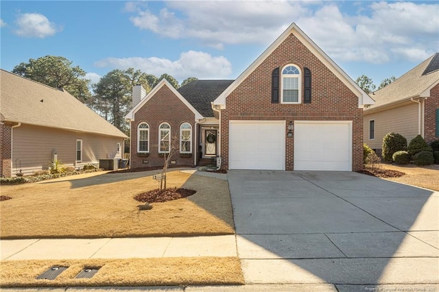 traditional home featuring central air condition unit, a garage, brick siding, driveway, and a chimney