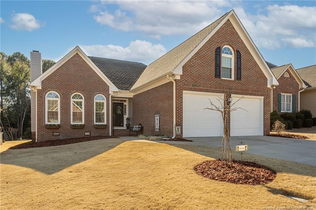 view of front of house with concrete driveway, brick siding, and a chimney