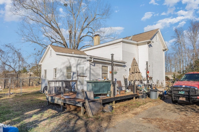 exterior space featuring a chimney, fence, and a deck