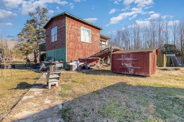 view of side of home featuring a yard, stairs, a storage unit, and an outdoor structure