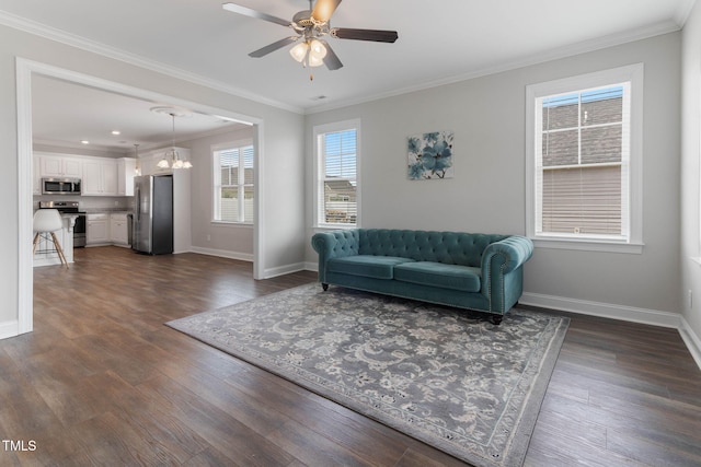 living area with dark wood-style floors, crown molding, baseboards, and ceiling fan with notable chandelier