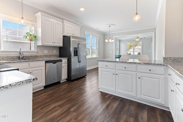 kitchen with appliances with stainless steel finishes, white cabinets, crown molding, and a sink