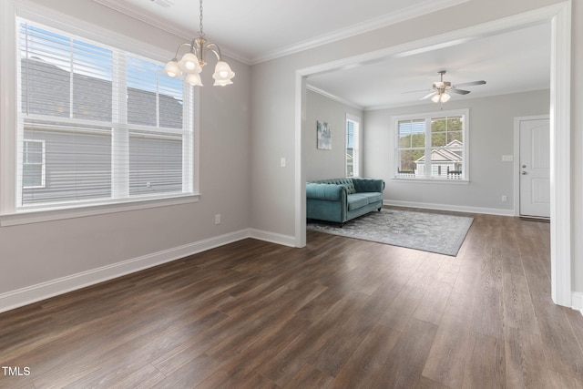 interior space featuring dark wood-style floors, ceiling fan with notable chandelier, baseboards, and crown molding