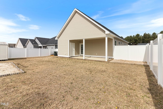 rear view of house featuring a patio area, a fenced backyard, and a yard