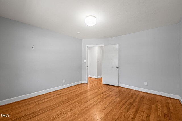 unfurnished room featuring baseboards and light wood finished floors