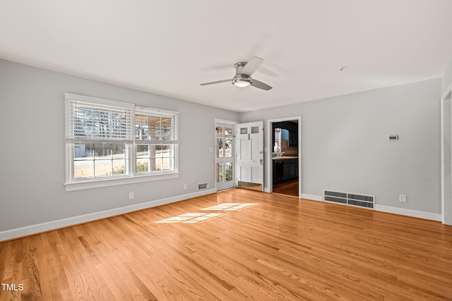 spare room featuring light wood-type flooring, baseboards, visible vents, and ceiling fan