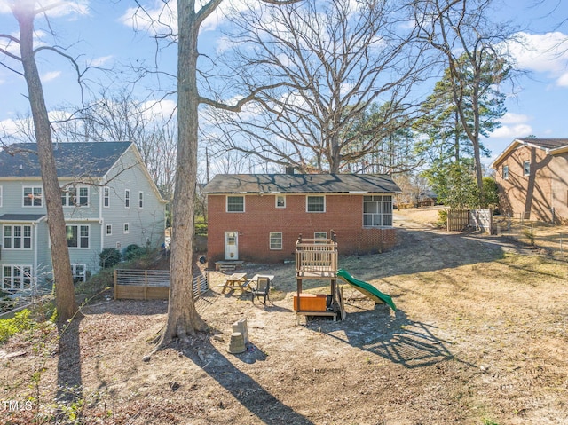 rear view of house with an outbuilding and brick siding