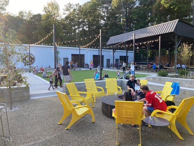 view of community featuring fence, a fire pit, and a gazebo