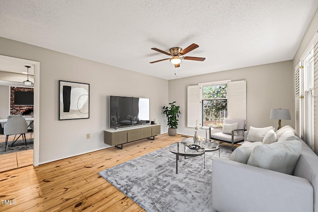 living room featuring a textured ceiling, ceiling fan, and hardwood / wood-style flooring