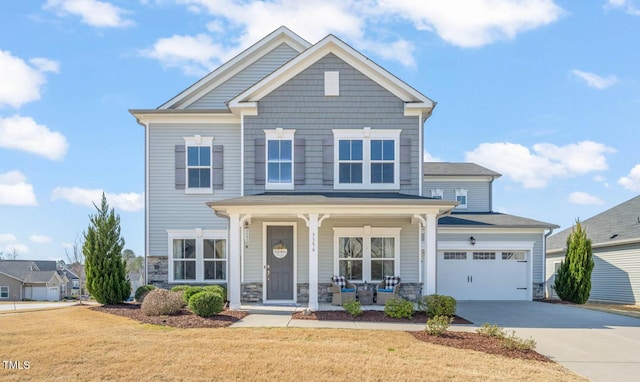 craftsman inspired home featuring a front lawn, a porch, a garage, stone siding, and driveway