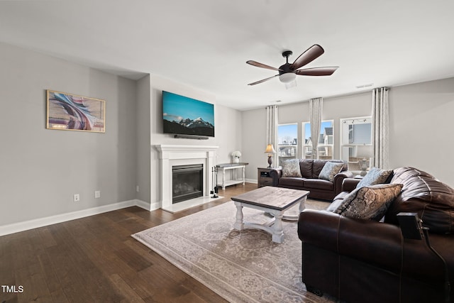 3356 Longleaf Estates Dr, Raleigh, NC 27616 - living area with visible vents, baseboards, a glass covered fireplace, a ceiling fan, and dark wood-style flooring