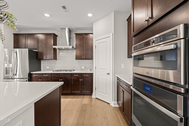 3356 Longleaf Estates Dr, Raleigh, NC 27616 - kitchen featuring tasteful backsplash, dark brown cabinets, wall chimney range hood, light countertops, and appliances with stainless steel finishes