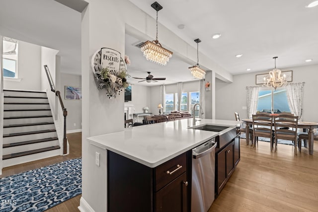 3356 Longleaf Estates Dr, Raleigh, NC 27616 - kitchen featuring ceiling fan with notable chandelier, a sink, stainless steel dishwasher, light wood finished floors, and light countertops