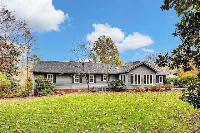 rear view of property featuring a lawn, a chimney, and fence