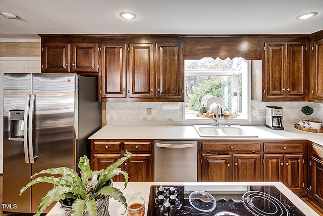 kitchen with stainless steel appliances, tasteful backsplash, a sink, and light countertops