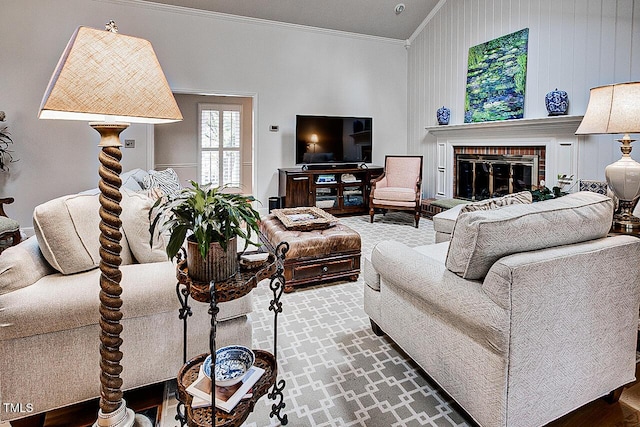 living area featuring vaulted ceiling, a brick fireplace, and crown molding