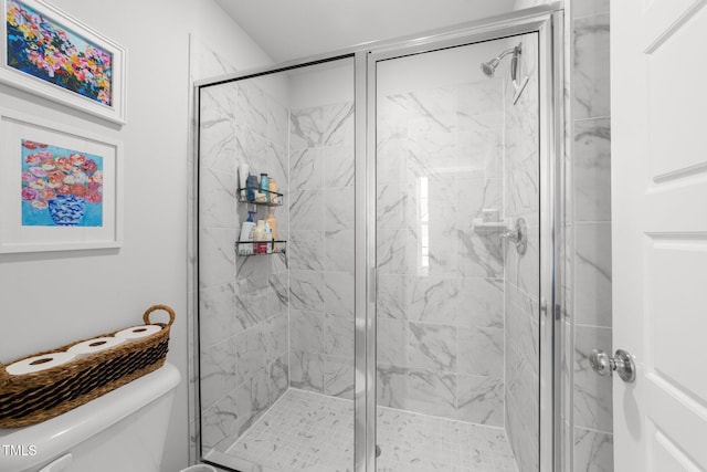 bathroom with a shower stall and toilet