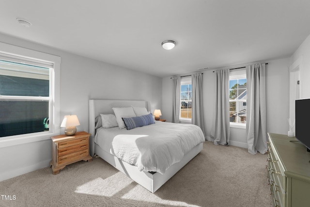 bedroom featuring light carpet and baseboards