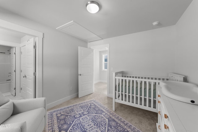 bedroom featuring baseboards, attic access, and light colored carpet