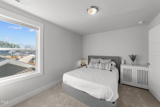 carpeted bedroom with visible vents and baseboards