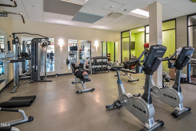 gym with a paneled ceiling and visible vents