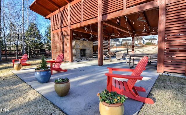 view of patio / terrace featuring an outdoor stone fireplace and fence