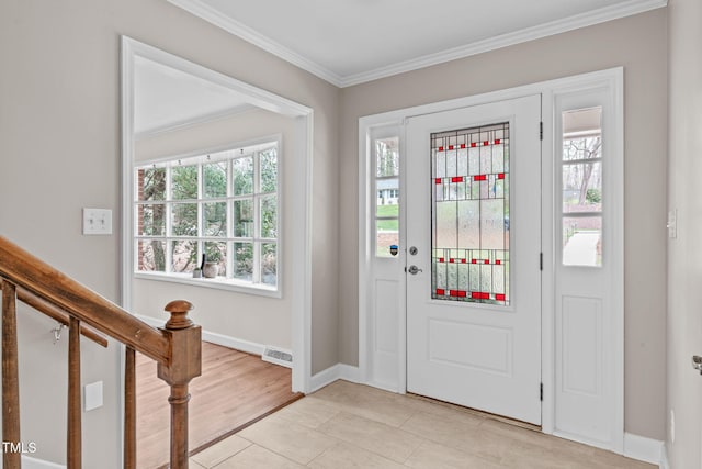 foyer with stairway, a healthy amount of sunlight, baseboards, and ornamental molding