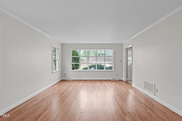 empty room with visible vents, crown molding, light wood-type flooring, and baseboards