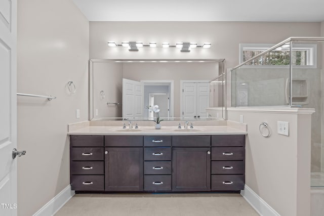 bathroom with double vanity, a stall shower, and a sink