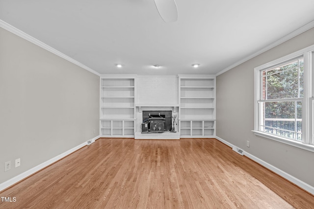 unfurnished living room featuring crown molding, light wood-style floors, and baseboards