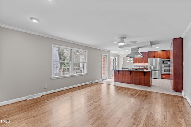 unfurnished living room with light wood finished floors, visible vents, crown molding, baseboards, and a ceiling fan