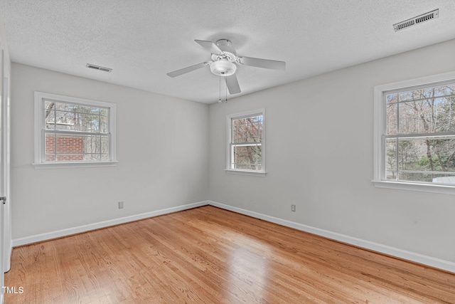 spare room featuring visible vents, baseboards, and wood finished floors