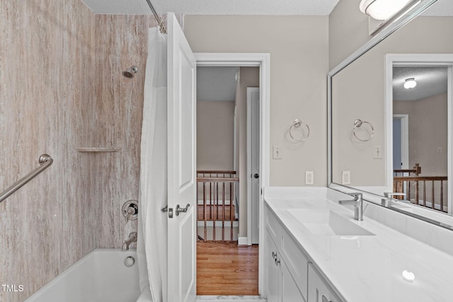 full bathroom with shower / tub combo, a textured ceiling, wood finished floors, and vanity