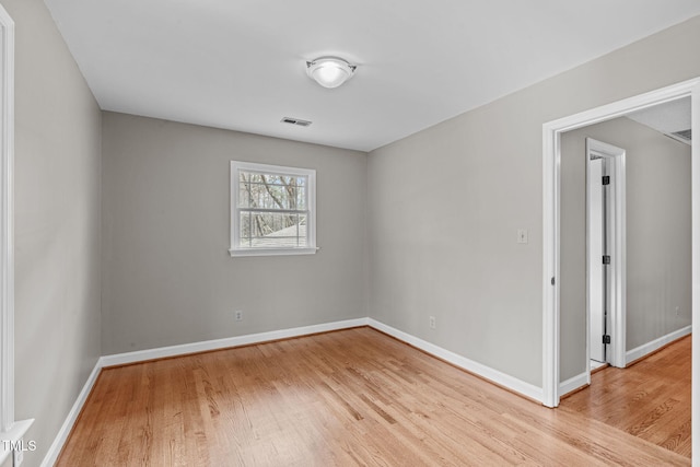 empty room featuring visible vents, baseboards, and light wood-style flooring