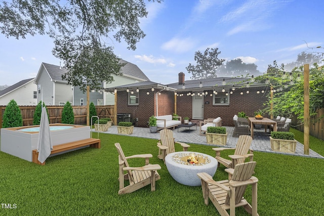 rear view of house with a fenced backyard, a patio, and a lawn