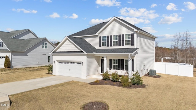 traditional-style home with driveway, roof with shingles, fence, central air condition unit, and a front yard