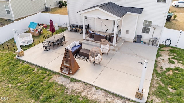 view of patio / terrace featuring a trampoline, outdoor dining area, a fenced backyard, and an outdoor hangout area