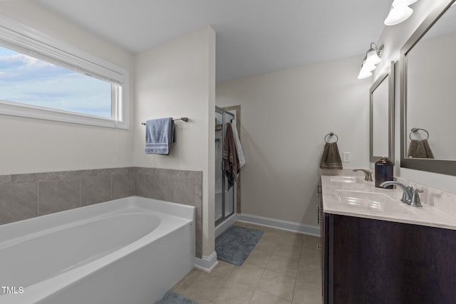 bathroom with a sink, a bath, tile patterned floors, double vanity, and a stall shower