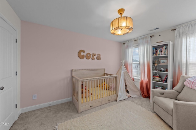 bedroom featuring a crib, carpet, visible vents, and baseboards