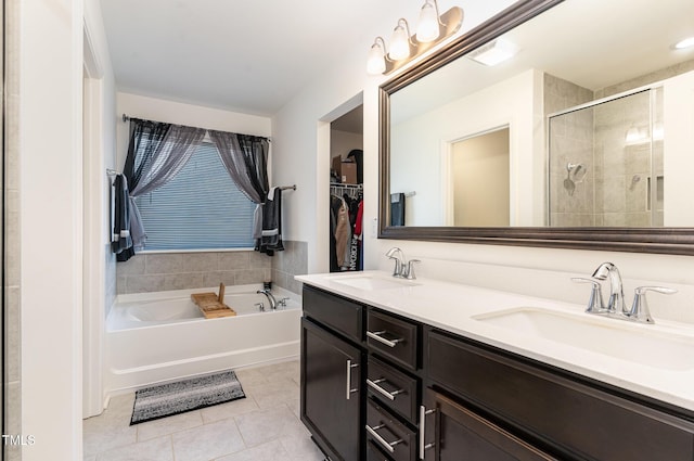 full bath with a sink, a garden tub, a shower stall, and tile patterned flooring