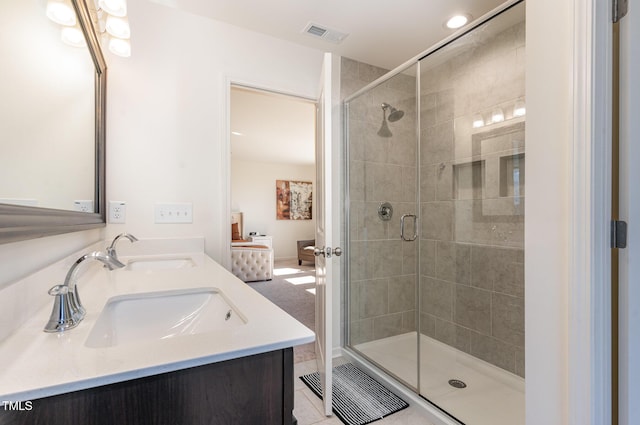 full bath featuring double vanity, visible vents, a stall shower, and a sink